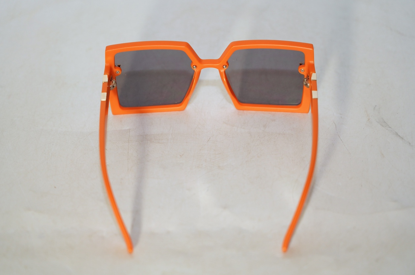 A pair of orange Hermes sunglasses